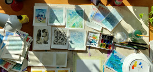 Akvarellimaalauksia pöydällä